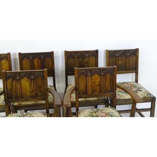 28 - A set of six early / mid 20thC oak and elm Gothic Ercol style dining chairs. The armchairs measuring... 