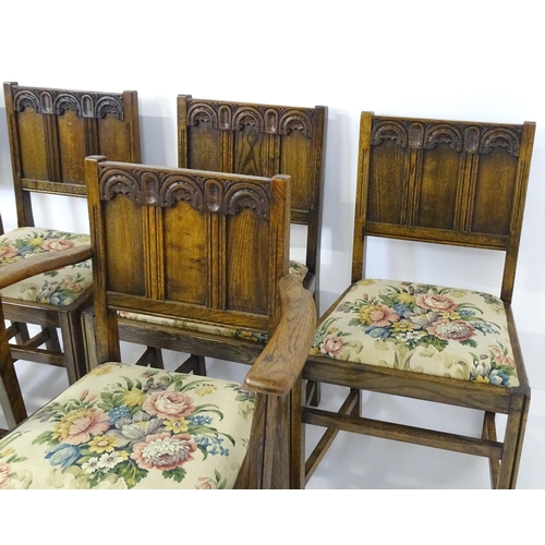 28 - A set of six early / mid 20thC oak and elm Gothic Ercol style dining chairs. The armchairs measuring... 