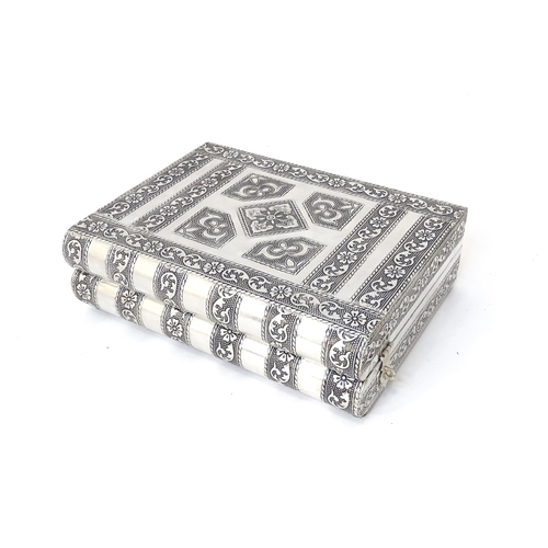 444 - An eastern style white metal jewellery box formed as two books,  with fitted sectional interior. Tog... 