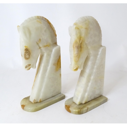 674 - A pair of onyx bookends of horse head form. Approx. 12