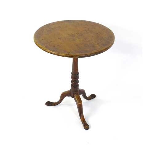 677 - An 18thC mahogany tripod table raised on a turned pedestal and three cabriole legs. 24