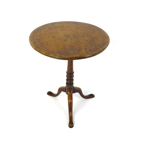 677 - An 18thC mahogany tripod table raised on a turned pedestal and three cabriole legs. 24