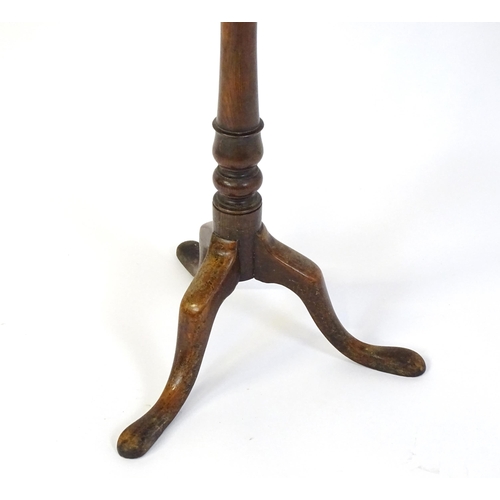 677 - An 18thC mahogany tripod table raised on a turned pedestal and three cabriole legs. 24