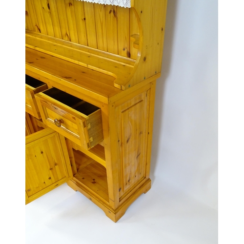 71 - A pine dresser with a three tier plate rack above three short drawers and three panelled cupboards w... 