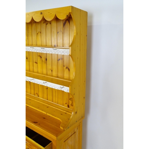 71 - A pine dresser with a three tier plate rack above three short drawers and three panelled cupboards w... 