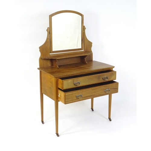 721 - An early 20thC mahogany dressing table with a shaped upstand, shelf and arched mirror. The top havin... 