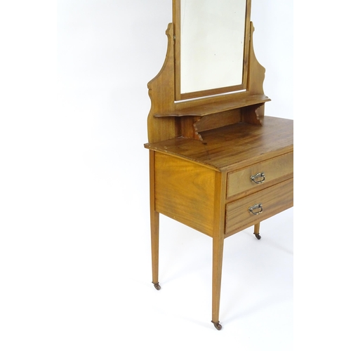 721 - An early 20thC mahogany dressing table with a shaped upstand, shelf and arched mirror. The top havin... 