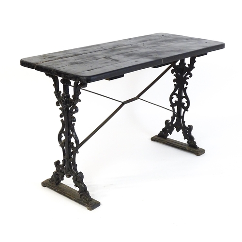 723 - A patio table with a three plank top above a cast iron base. 45