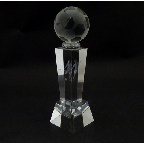 785 - A glass football trophy of tapering form with footballer detail to centre. Approx. 6 3/4