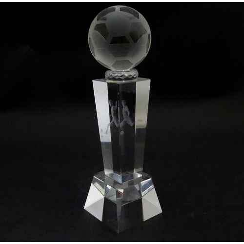 785 - A glass football trophy of tapering form with footballer detail to centre. Approx. 6 3/4