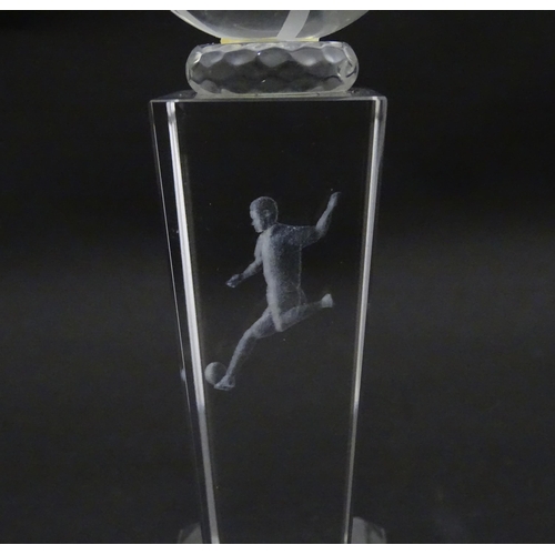 785 - A glass football trophy of tapering form with footballer detail to centre. Approx. 6 3/4