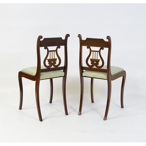 851 - A pair of mid  / late 20thC mahogany side chairs with lyre shaped back splats and raised on sabre le... 