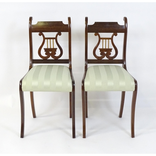 851 - A pair of mid  / late 20thC mahogany side chairs with lyre shaped back splats and raised on sabre le... 