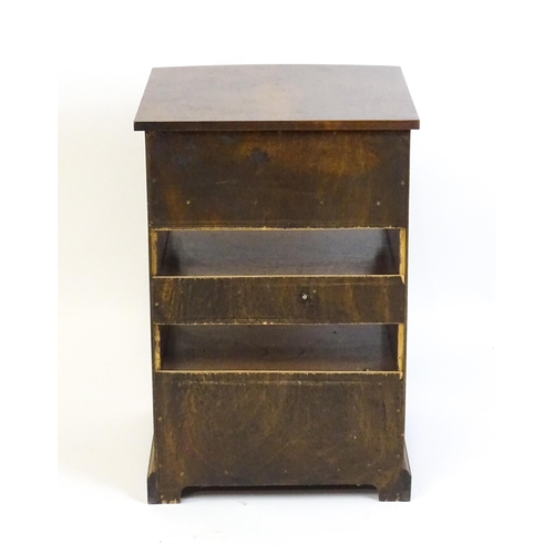 884 - A walnut veneered chest with three small drawers and two shelves raised on short bracket feet. 20