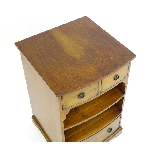 884 - A walnut veneered chest with three small drawers and two shelves raised on short bracket feet. 20