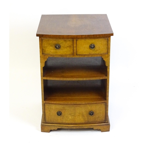 884 - A walnut veneered chest with three small drawers and two shelves raised on short bracket feet. 20