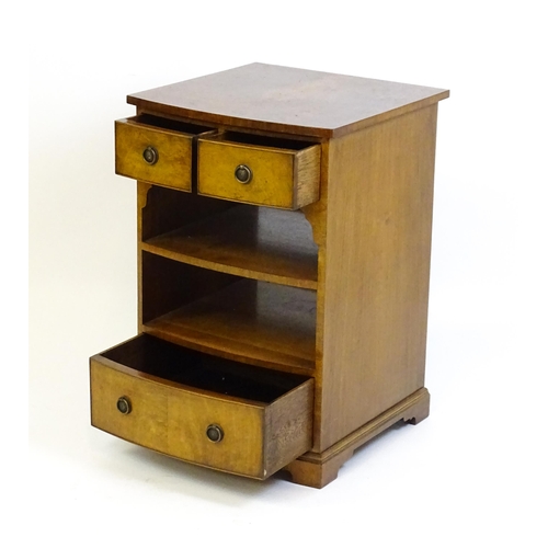 884 - A walnut veneered chest with three small drawers and two shelves raised on short bracket feet. 20