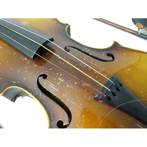 889 - A mid 20thC Bohemian violin, cased with two bows. The instrument approx 23 1/2