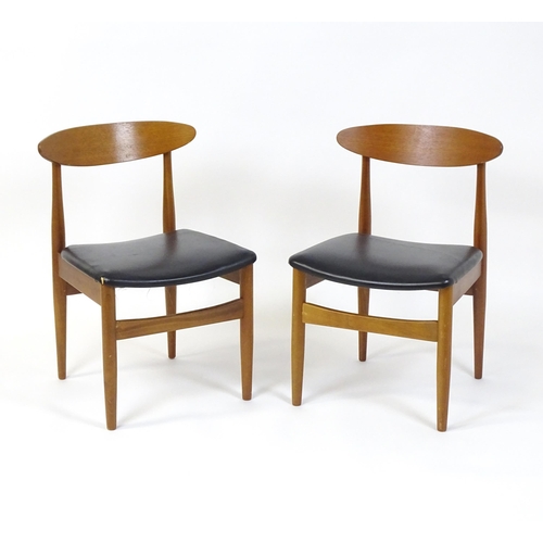 913 - Vintage / Retro: A pair of teak dining chairs raised on turned tapering legs. 20