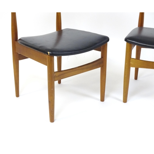 913 - Vintage / Retro: A pair of teak dining chairs raised on turned tapering legs. 20