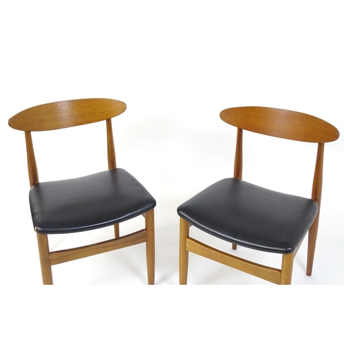 913 - Vintage / Retro: A pair of teak dining chairs raised on turned tapering legs. 20