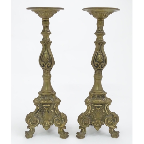 158 - A pair of cast candlesticks with scrolling detail. Approx. 12