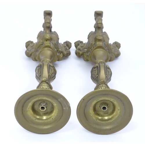 158 - A pair of cast candlesticks with scrolling detail. Approx. 12