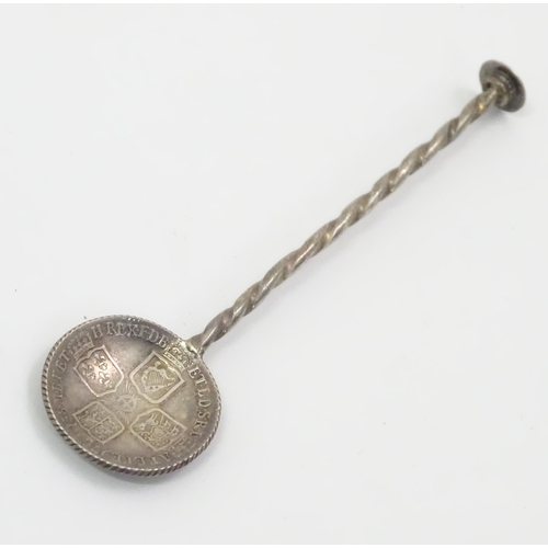 438 - A white metal salt spoon, the bowl with Geo II stylised coin detail. Approx. 3 1/2