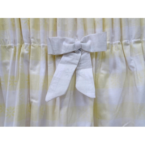 596 - A pair of curtains decorated in a yellow and white check pattern with bow detail. Together with a ma... 