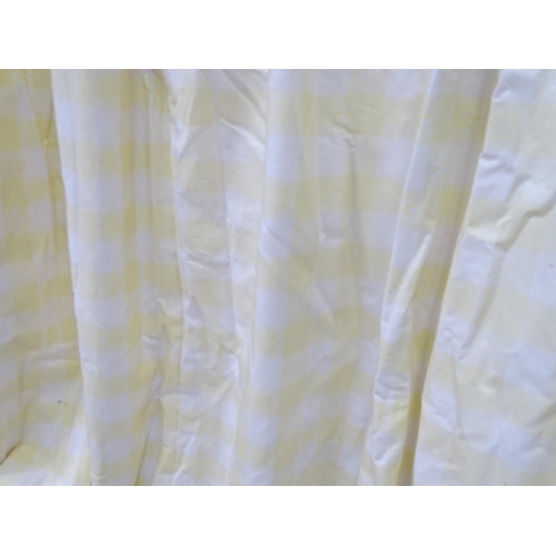 596 - A pair of curtains decorated in a yellow and white check pattern with bow detail. Together with a ma... 