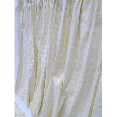 596 - A pair of curtains decorated in a yellow and white check pattern with bow detail. Together with a ma... 