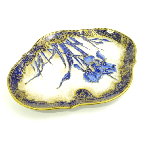 637 - A Doulton Burslem plate of shaped form decorated with Iris flowers. Marked under.