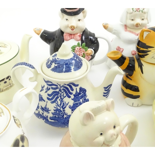 715 - A quantity of teapots to include novelty bride and groom pigs, cottages, treacle glaze examples, etc... 