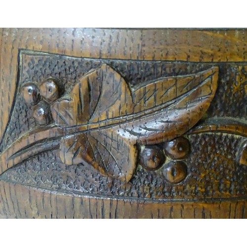 801 - An early 20thC oak pedestal salad bowl with carved foliate decoration and brass handles and mounts. ... 