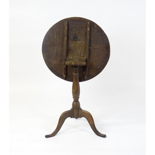 152 - An 18thC oak tripod table with a circular top above a turned pedestal and three cabriole legs. 27