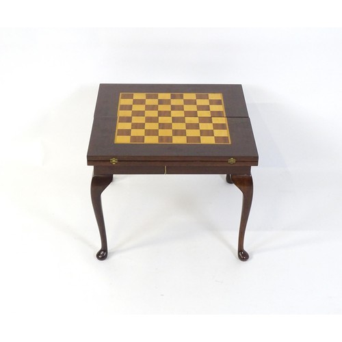 250 - A late 20thC / early 21stC games table with two inlaid playing boards and additional chess pieces an... 