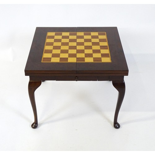 250 - A late 20thC / early 21stC games table with two inlaid playing boards and additional chess pieces an... 