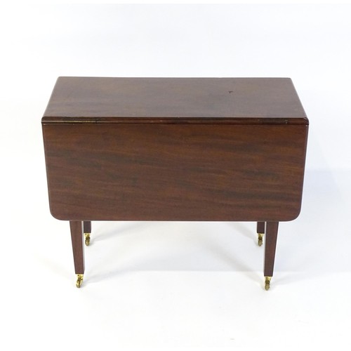 251 - A 20thC mahogany Pembroke table raised on four tapering legs terminating in brass caps and castors. ... 