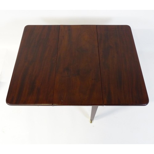 251 - A 20thC mahogany Pembroke table raised on four tapering legs terminating in brass caps and castors. ... 