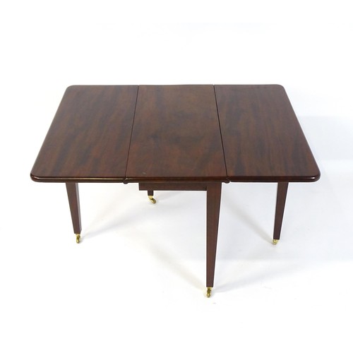 251 - A 20thC mahogany Pembroke table raised on four tapering legs terminating in brass caps and castors. ... 