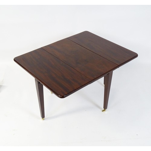 251 - A 20thC mahogany Pembroke table raised on four tapering legs terminating in brass caps and castors. ... 