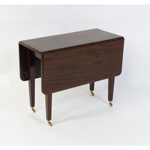 251 - A 20thC mahogany Pembroke table raised on four tapering legs terminating in brass caps and castors. ... 