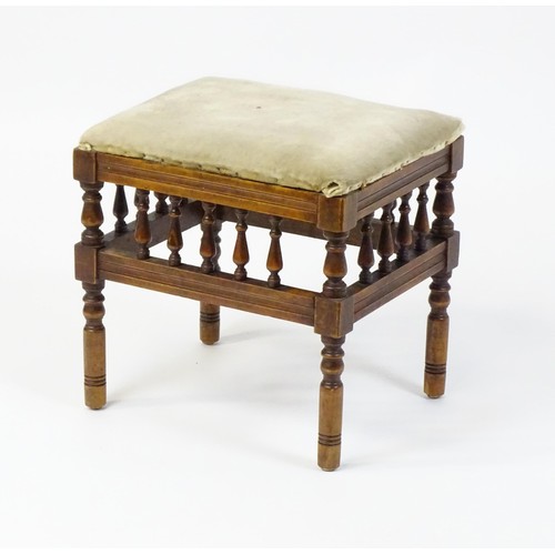 598 - An Aesthetic Movement footstool, the upholstered seat above a gallery with turned supports and stand... 