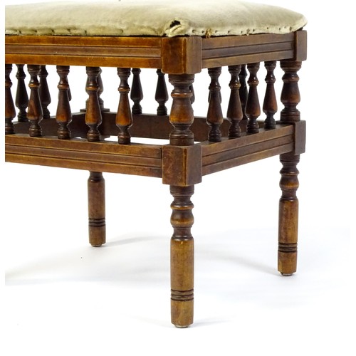 598 - An Aesthetic Movement footstool, the upholstered seat above a gallery with turned supports and stand... 