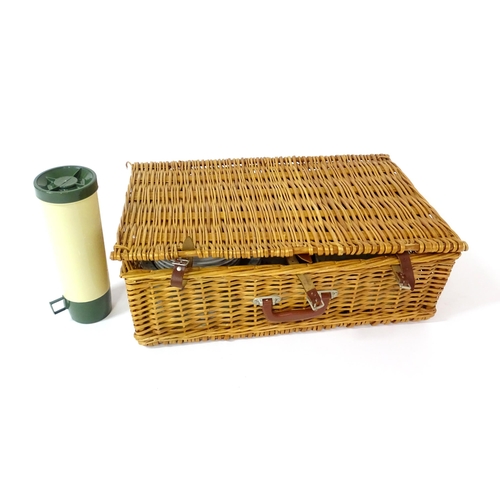 630 - A wicker picnic basket containing plastic plates, bowls, mugs, etc. with floral decoration, cutlery,... 