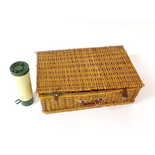 630 - A wicker picnic basket containing plastic plates, bowls, mugs, etc. with floral decoration, cutlery,... 