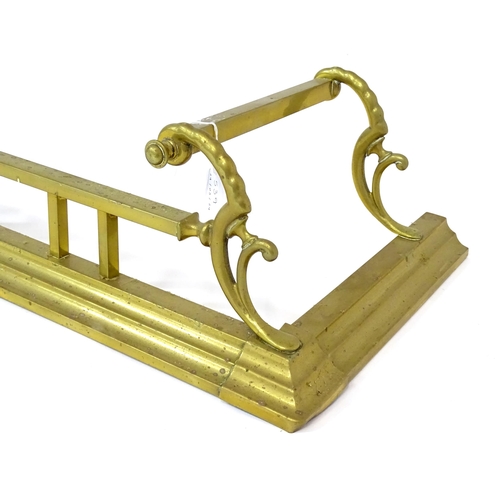 539 - A brass fire fender with scrolling supports,  approx 53 1/2