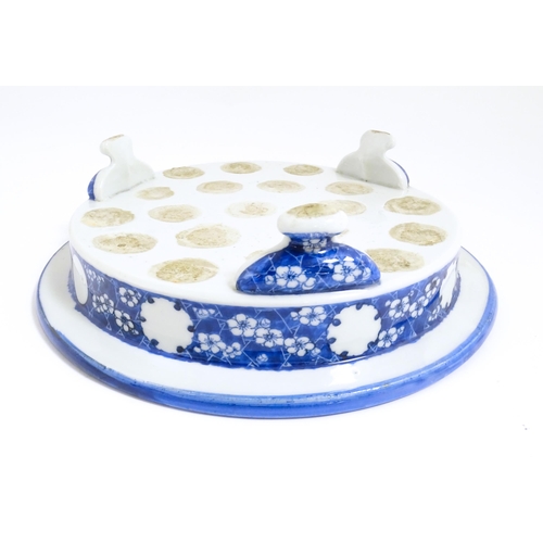 39 - A Chinese blue and white stand of circular form raised on three feet decorated with prunus flowers. ... 