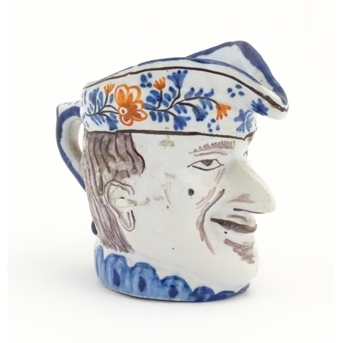 77 - A French faience character / Toby jug, possibly modelled as Mr Punch. Approx. 3 1/4