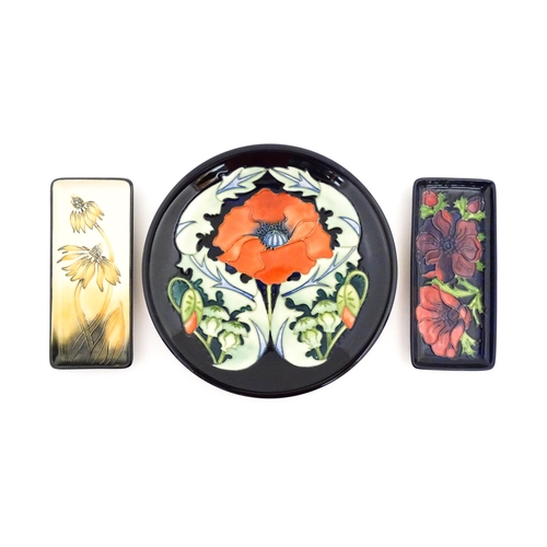 134 - A Moorcroft plate decorated in the Poppy plate designed by Rachel Bishop. Together with two oblong d... 